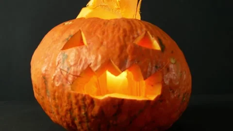 One orange pumpkin on black background with Jack o Latern face with copy spac Stock Footage 211807820