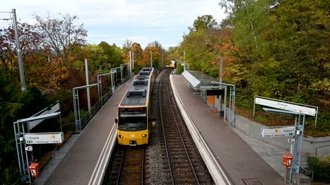 One outgoing and one approaching yellow streetcar at a station, 4K Stock Footage 227010677