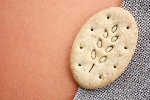 One oval multigrain biscuits on canvas closeup. Copy space. Stock Photos