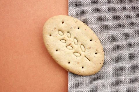 One oval multigrain biscuits on canvas closeup. Copy space. Stock Photos