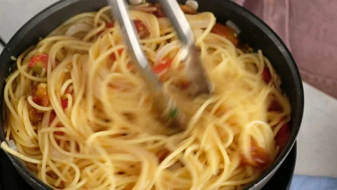 ONE PAN PASTA. Close-up shot of a female chef a pan cooking a pasta dish and Stock Footage 143729974