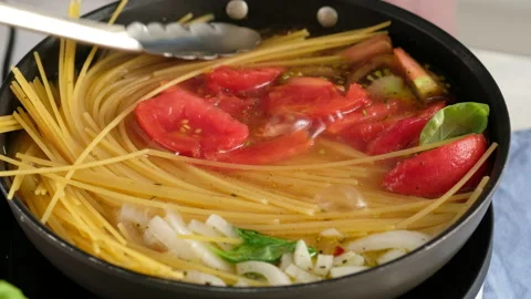 ONE PAN PASTA. Close-up shot of a female chef a pan cooking a pasta dish and Stock Footage 147046311