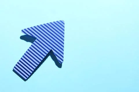 One paper arrow on light blue background, top view. Space for text Stock Photos