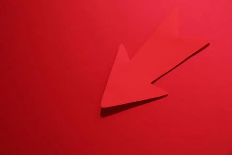 One paper arrow on red background, top view. Space for text Foto stock