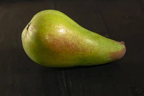 One pear green closeup black background Stock Photos
