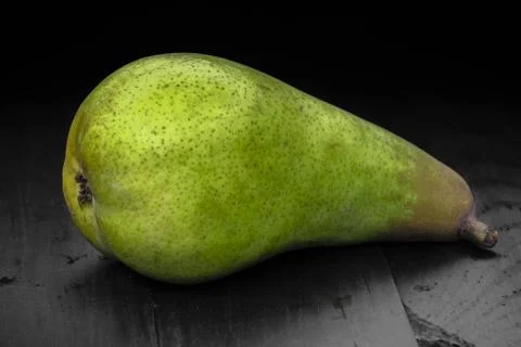 One pear green closeup black background Stock Photos