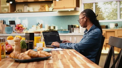One person coding on laptop in kitchen representing remote work Stock Footage 344244252