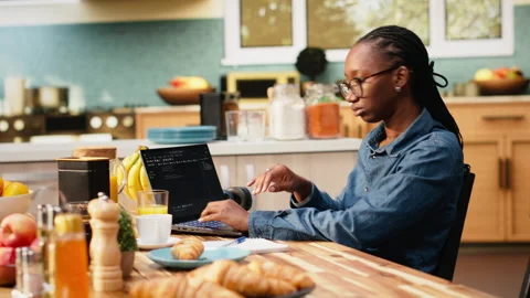 One person coding on laptop in kitchen representing remote work Stock Footage 344246832