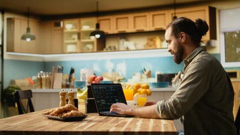 One person coding on laptop in a kitchen representing remote work in IT Foto stock