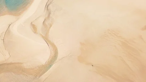 One person exercising between shallow water lagoons on the coastline Stock Footage 127992057