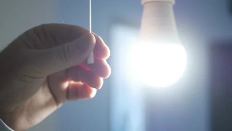 One Person Pull the Switch Cord and Turns On the Light Bulb in a Dark Room. Stock Footage 152499500