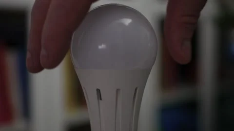 One Person Screws a Led Light Bulb in the Socket and Turn On the Light in the Stock Footage 333067239