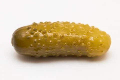 One pickled cucumber cut in half on white background Stock Photos
