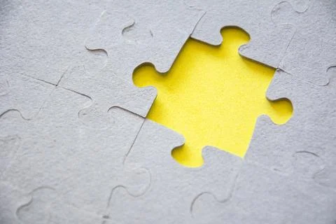 One piece missing from jigsaw puzzle on yellow background. Stock Photos
