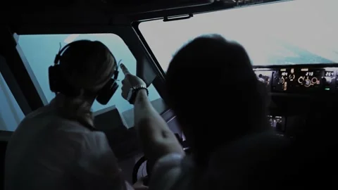 One pilot points to something interesting in the sky in the cockpit Stock Footage 219803059