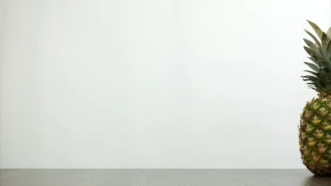 One pineapple rotating on the desk on white background. Stop motion Stock Footage 81351717