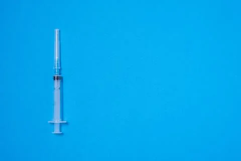 One plastic disposable injection syringe on a blue background Foto stock