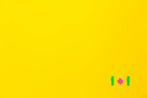 One plus 1 equals two is example on yellow background. Copy space. Math Stockfoto's