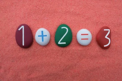 One plus two equals three, creative addition with colored stone numbers Stock Photos
