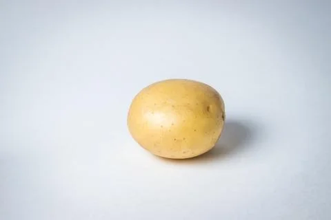 One potato on a white background.  Stock Photos