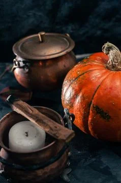 One pumpkin squash and copper or brass witch pots with candles and palo santo Stock Photos