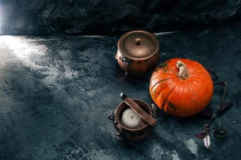 One pumpkin squash and copper or brass witch pots with candles and palo santo Stock Photos