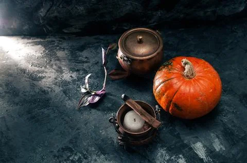 One pumpkin squash and copper or brass witch pots with candles and palo santo Stock Photos