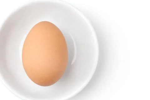 One raw egg on white plate on white background from top view with space for c 写真素材