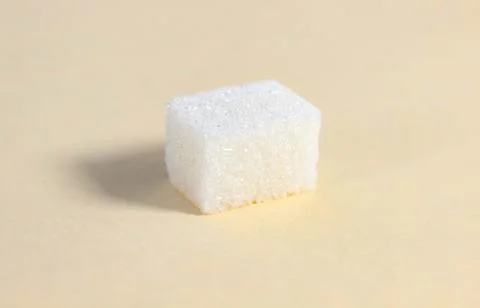 One rectangular sugar cube on a beige background. 스톡 사진