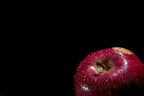 One red Apple with dew drops on a dark background Stock Photos