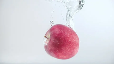 One red apple fall into the water with splashes and bubbles in slow motion. Stock Footage 144193501