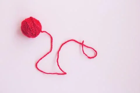 One red ball of woolen thread on a pink background Stock Photos