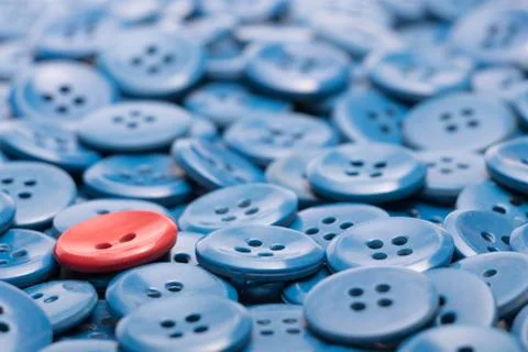 One red button on a heap of blue buttons Stock Photos