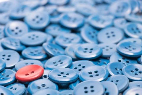 One red button on a heap of blue buttons left based Stock Photos