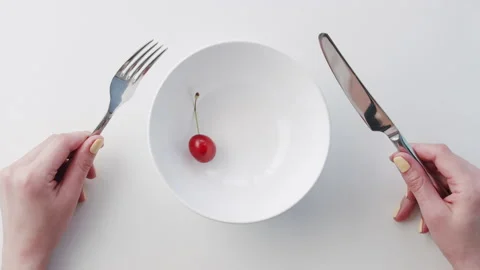 One red cherry berry fall from height on isolated empty platter with knife and Stock Footage 147344587