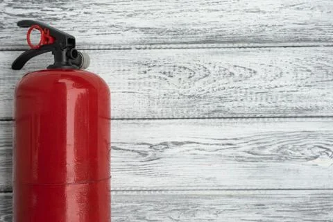 One red hand extinguishers on a light wooden background. Copy space. The conc Stock Photos