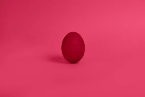 One red painted Easter egg stand on a pink background. Stock-Fotos