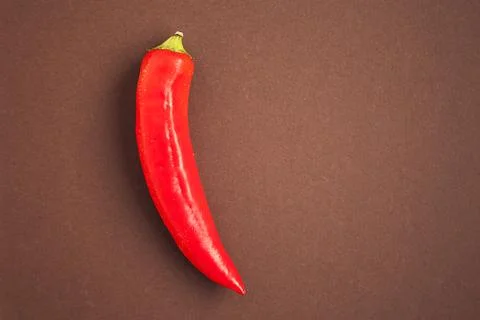 One red pepper on the brown background Stock Photos