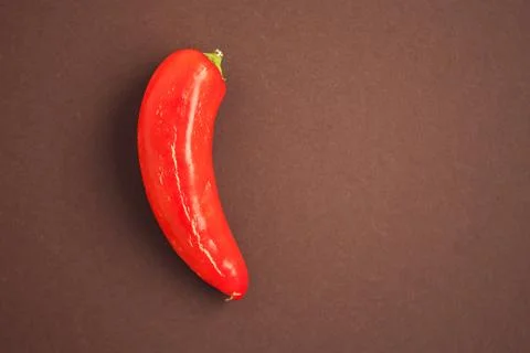 One red pepper on the brown background Stock Photos