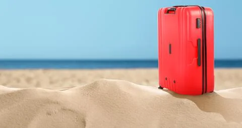 One red suitcase on sandy beach near sea. Banner design with space for text Stock-Fotos