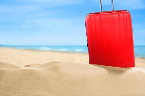 One red suitcase on sandy beach near sea. Space for text Stock-Fotos