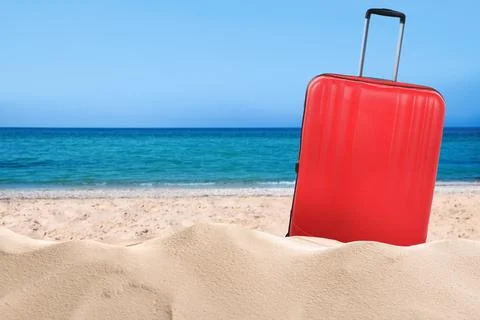 One red suitcase on sandy beach near sea. Space for text Stock-Fotos