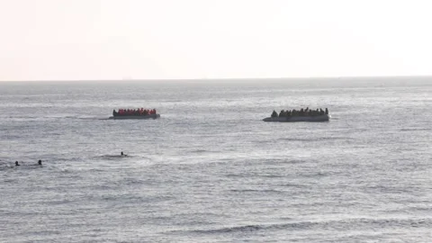 One refugee boat going to help another refugee boat that has no engine near  스톡 동영상 145910288