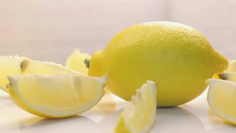 One Ripe Lemon Rotating On White Surface With Juicy Slices Around Stock Footage 112267809