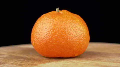 One Ripe Orange Fruit is Rotating on a W... | Stock Video | Pond5