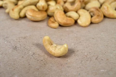 One roasted cashew and cachews on background Fotos de archivo