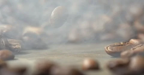 One roasted coffee bean falling onto wooden table in super slow motion Stock Footage 342590508