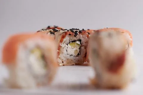 One roll in focus, a portion of rolls out of focus, Asian food, sushi and fish Stock Photos