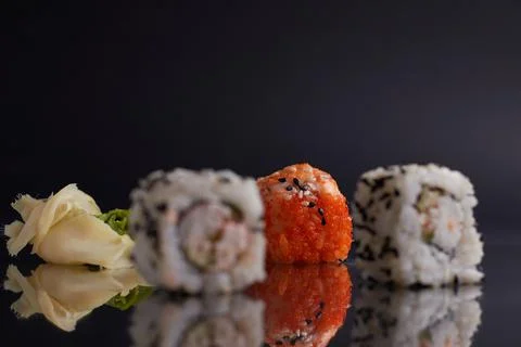 One roll in focus, a portion of rolls out of focus, Asian food, sushi and fish Stock Photos
