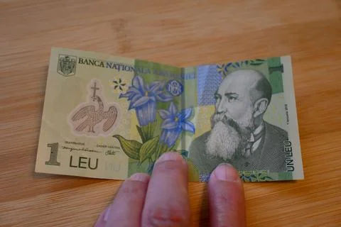 One Romanian Leu Banknote on Table with hand, Cost of Living Concept Stock Photos